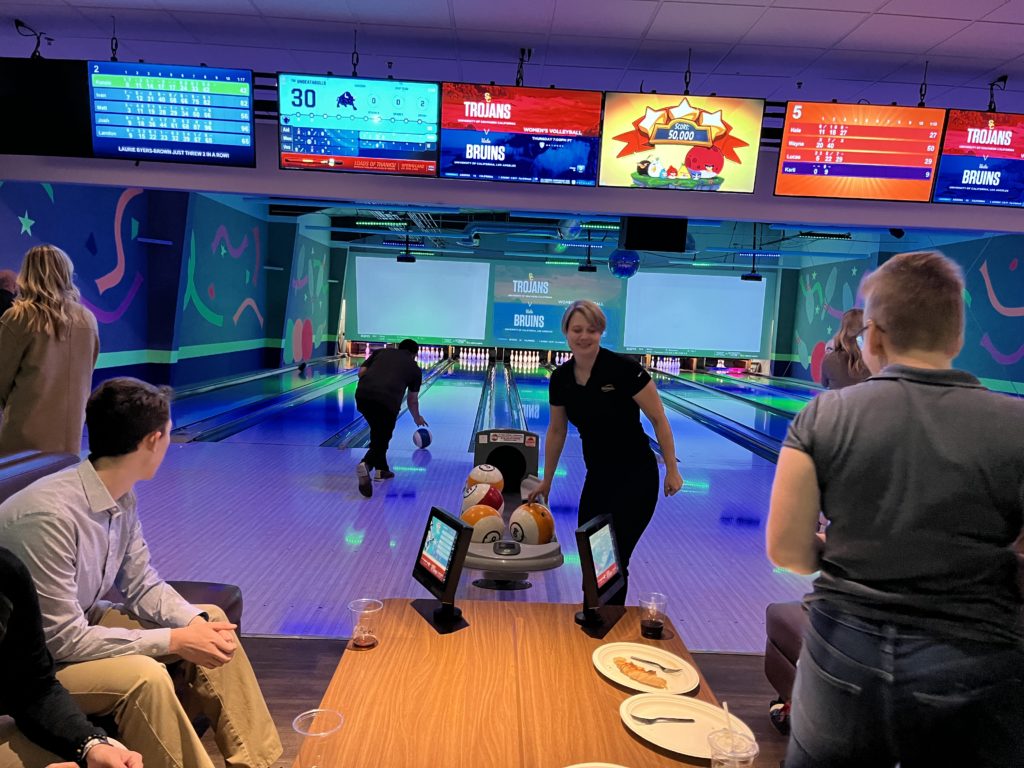 A group of students and business representatives enjoy a night of bowling